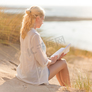 女人喜欢在美丽的沙滩上阅读。