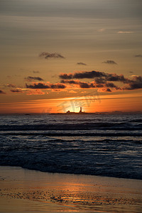 红色纱布摄影照片_与灯塔黄色红色的日落 Hellsto 海滩
