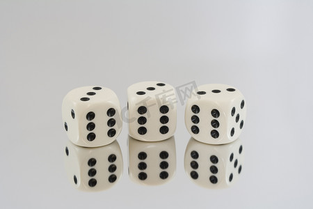 骰子三个六摄影照片_三个带有黑色斑点和反射的白色骰子