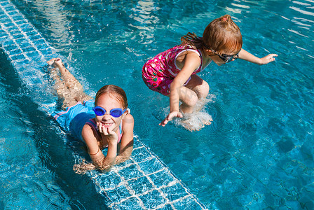 两个快乐的小女孩在游泳池里嬉戏