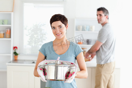 女人拿着锅，男人洗碗