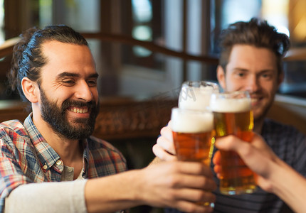 快乐的男性朋友在酒吧或酒馆喝啤酒