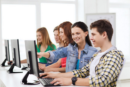 男学生和同学一起上电脑课
