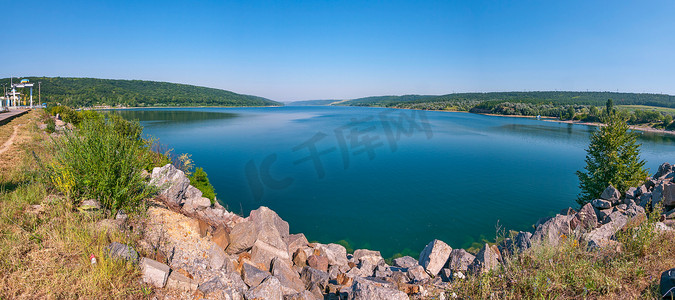 深蓝色的湖面映衬着缓缓倾斜的绿色山脊