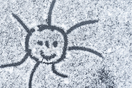 微笑的太阳画在雪地上。软焦点。