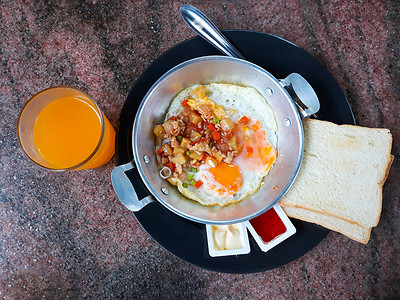 煎鸡蛋配配料、面包和橙汁。