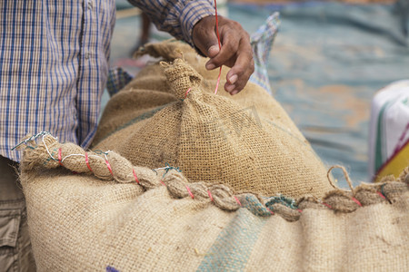 粗麻布袋中的农民和水稻种子