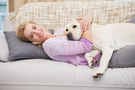 沙发上的漂亮金发女郎和宠物狗