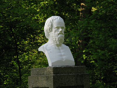 绿树成荫的公园背景中一位著名历史人物的石膏半身像