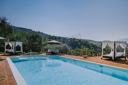 意大利带游泳池的豪华乡间别墅，意大利豪华别墅度假的情侣，男人和女人看日落