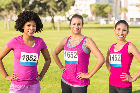 三位微笑的赛跑者支持乳腺癌马拉松