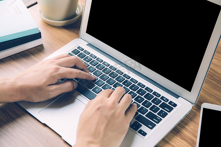 人手工作笔记本电脑与空白屏幕，在家工作以分散社交注意力是新常态，自由职业者使用在工作区、业务和通信概念上显示为空的笔记本。