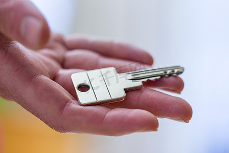 搬进新家：拿着钥匙的手的特写。