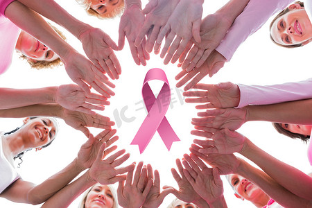 因患乳腺癌而身穿粉色衣服的快乐女性围成一圈的合成图像