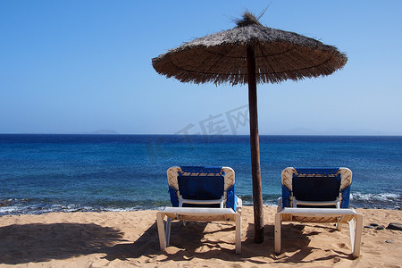 热带海滩伞下的太阳椅