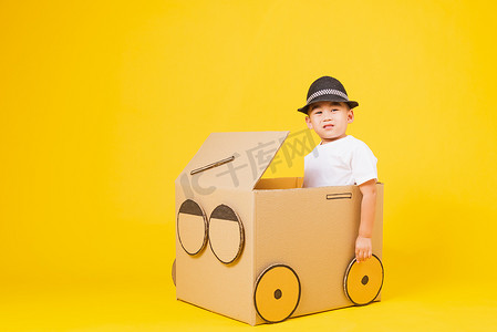 开心驾驶摄影照片_cardb创意的小男孩开着车笑得很开心