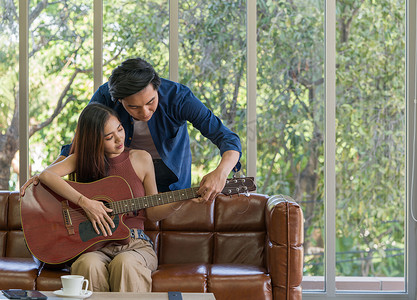 这个年轻人教他的女朋友弹吉他。