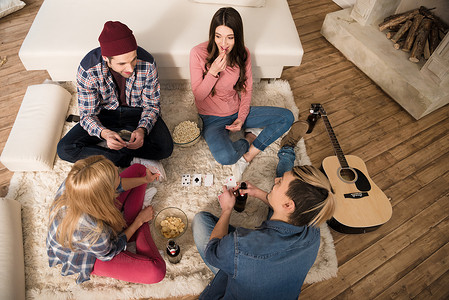 男人和女人在家里打牌和吃爆米花的顶视图