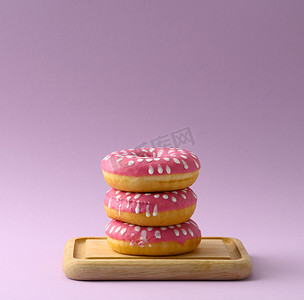 一堆粉色甜甜圈，紫色背景上有糖霜
