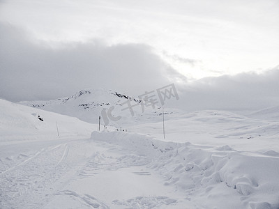 驾车摄影照片_驾车穿过挪威的雪路和风景。