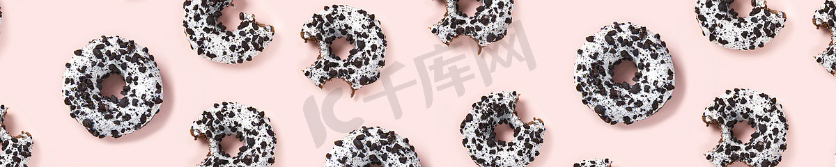 糕点海报摄影照片_粉红色背景顶视图上的甜甜圈。