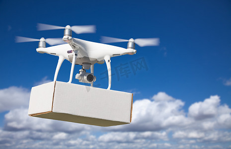 无人驾驶飞机系统 (UAS) 四旋翼无人机在空中携带空白包裹。