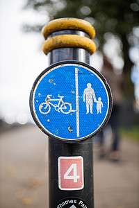 杆子上的蓝色标志指示行人和骑自行车的人的路径