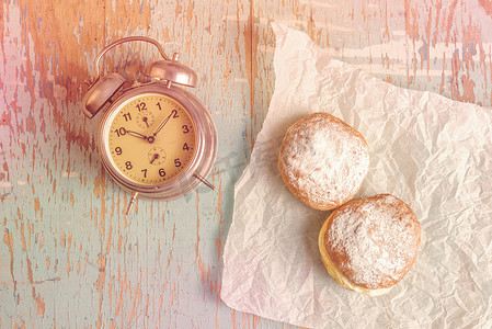 乡村餐桌上的甜甜甜甜圈和古董钟