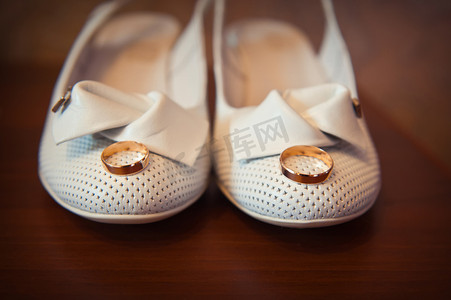 新娘白鞋上的金戒指特写