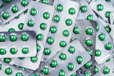 泡罩中圆形绿色糖衣片药丸的特写堆