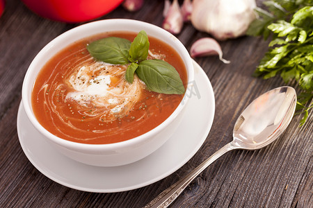 美味的番茄汤与木制的桌子上的香料。