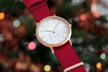 红色正式摄影照片_圣诞灯前的红色尼龙表带腕表