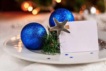 节日餐桌摄影照片_用圣诞球和珠子装饰的节日餐桌