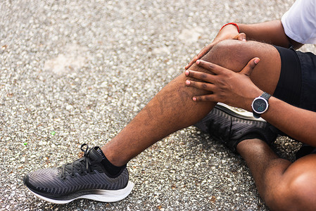 跑步者黑人戴着手表坐着 他在跑步时用手关节支撑膝盖