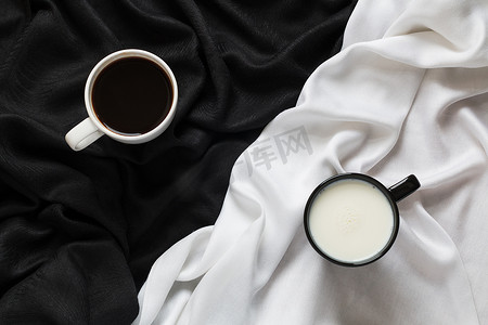 黑色或白色织物上的两杯咖啡和牛奶。