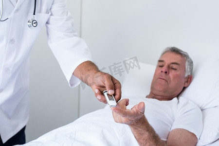 男医生用血糖仪检测老人糖尿病