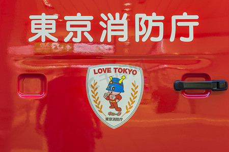 安全吉祥物摄影照片_带表意文字的红色日本消防车门把手的视图