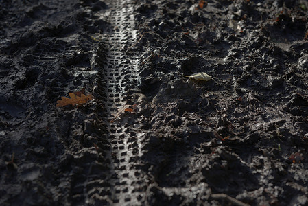 踏面摄影照片_2 - 深冬季节泥浆中的脚印和自行车道更轻。