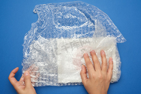 空气循环摄影照片_两只女手用透明塑料包裹物品