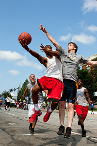 街头篮球摄影照片_男子在户外街头篮球比赛中向后卫投篮