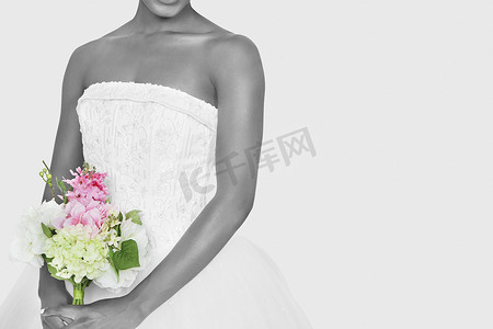 新娘花束摄影照片_灰色背景下手持花束的新娘中段