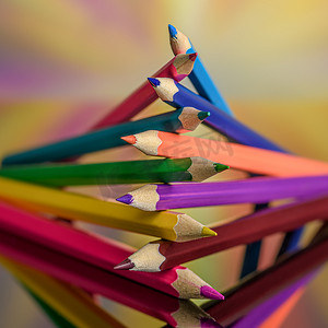 彩色铅笔创意艺术摄影照片_反光表面上的彩色铅笔