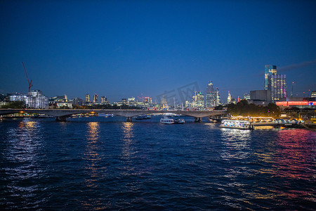 夜晚的泰晤士河，城市的灯光倒映在水面上