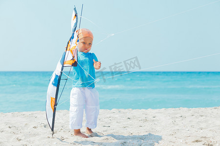 沙滩上玩彩色风筝的可爱男孩