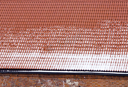 雪粘土瓦屋顶红砖墙背景冬天