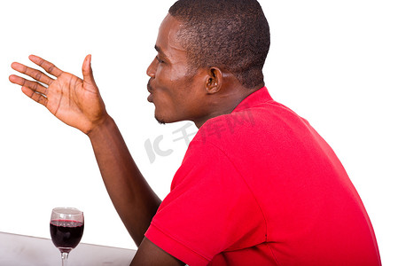 坐在餐厅前的年轻男子端着一杯酒