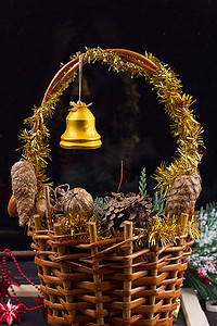 柳条花环摄影照片_圣诞装饰品，篮子里放着珠子、松果和橡子的花环