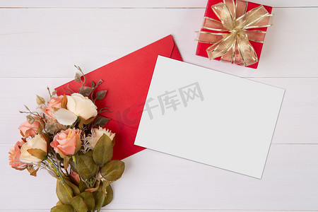情人节、贺卡模型、木桌上的字母和花朵、空白明信片和桌上浪漫的礼品盒、周年纪念日和庆祝活动、顶视图、假日概念。