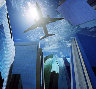 飞机飞过摄影照片_飞机飞过摩天大楼