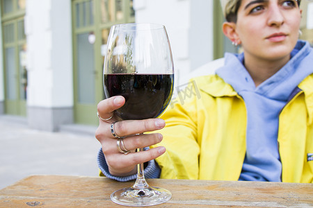 白酒红酒摄影照片_酒杯中的格鲁吉亚红酒、酒精饮料和女人的手